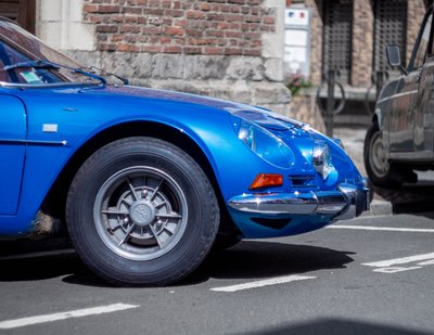 Detailed front quarter shot of a blue Alpine A110 classic sports car during a vintage car gathering