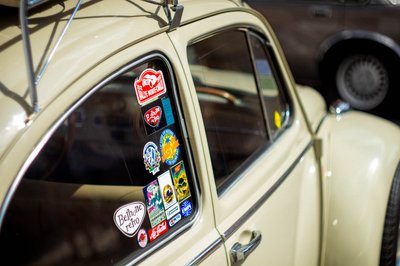 Close-up automotive photography of a classic Volkswagen Beetle with vintage rally stickers and cinematic retro car details