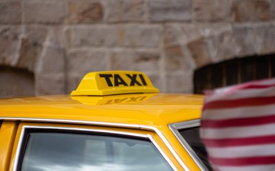 Vintage yellow taxi roof sign captured with shallow depth of field during a classic car exhibition